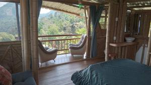 a bedroom with a balcony with a bed and chairs at Cabañas la pradera in Ruiosucio