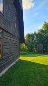 a side of a building with green grass next to it at Viešnagė gamtos prieglobstyje in Gūragiai