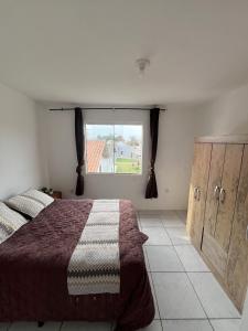 a bedroom with a large bed and a window at Apartamento em Garopaba in Garopaba
