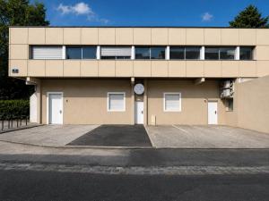a building with a parking lot in front of it at Eaux Spa Rive Droite in Rouen