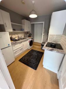 a kitchen with white appliances and a black rug at The City Walls Residence in Waterford