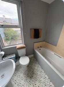 a bathroom with a tub and a toilet and a sink at The City Walls Residence in Waterford