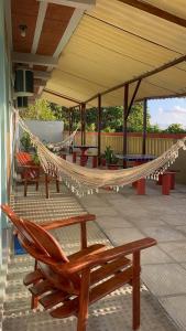 a hammock on top of a patio with chairs at Villa Velha Flats in Itamaracá