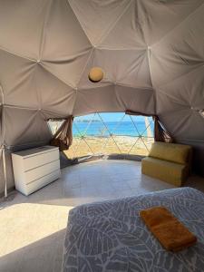 a bedroom with a bed and a view of the ocean at Dôme en face de la Passe de Tiputa in Rangiroa