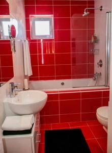 a red bathroom with a white sink and a tub at Garden in Šibenik