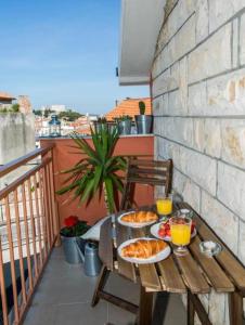 a table with two plates of food on a balcony at Garden in Šibenik +16 photos
