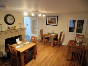 a dining room with two tables and a fireplace at Barrowgarth Guest House in Appleby
