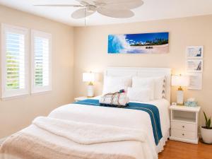 a white bed in a bedroom with a ceiling fan at Balloons and Wine in Murrieta