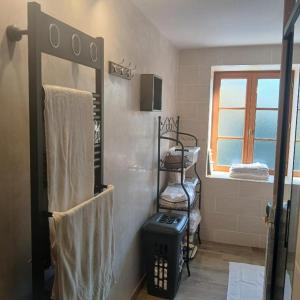 a bathroom with a towel rack and a window at Chez Phil et Marie in Pralong