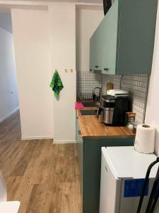 a kitchen with green cabinets and a wooden floor at Bazaleti Lake Escape in Bazalet'i +3 photos