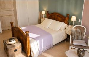 a bedroom with a large bed and a chair at Chambre des Alpilles in Eygalières