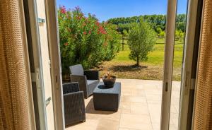 a door to a patio with two chairs and a table at Chambre des Alpilles in Eygalières +4 photos