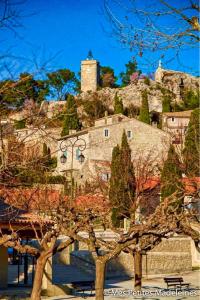 a large building with a clock tower on a hill at Chambre des Alpilles in Eygalières