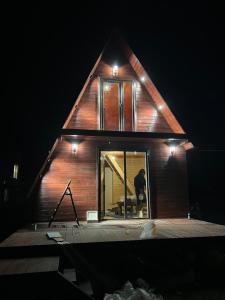 a house with a window on a deck at night at Kazbegi mountain station in Kazbegi