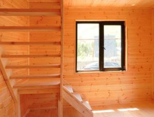 a log cabin with a window and stairs at Kazbegi mountain station in Kazbegi