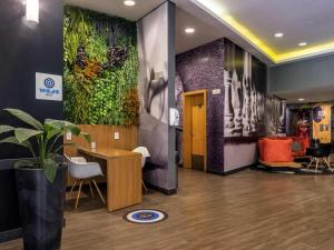 a lobby with a large painting on the wall at ibis Sao Jose do Rio Preto in Sao Jose do Rio Preto