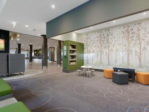an office with a lobby with trees on the wall at Novotel Berlin Mitte in Berlin