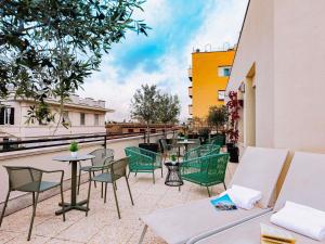 a patio with tables and chairs on a building at Mercure Roma Piazza Bologna in Rome