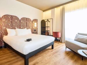 a hotel room with a bed and a couch at Ibis Styles Madrid Centro Maravillas in Madrid