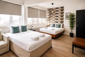 a hotel room with two beds and a couch at Centerstay Brussels in Brussels