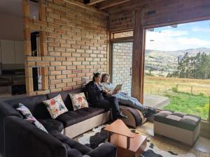 two people sitting on a couch in a living room at Pakarina WASY in San Miguel