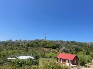 a small house with a red roof in a field at Cottage Kolomza in Ulcinj