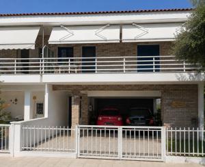 a house with two cars parked in the garage at Alice Apartment in Olympic Beach