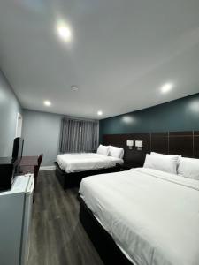 a hotel room with two beds and a flat screen tv at Countryside Inn in Kingston