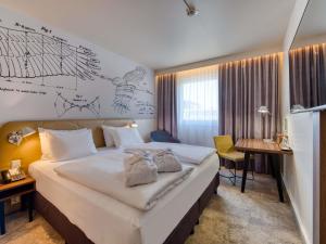 a hotel room with a large bed and a desk at Mercure Hotel Berlin City in Berlin