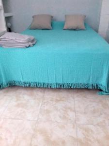 a bed with a turquoise blanket and pillows at centro 1 in General Roca