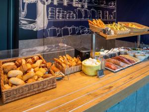 a buffet with baskets of bread and other food at ibis budget Berlin Alexanderplatz in Berlin