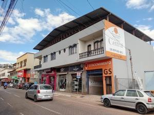 a street with cars parked in front of a building at Pousada Central Itabirito in Itabirito