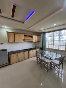 a large kitchen with a glass table and chairs at Nathigali A & M resort in Nathia Gali +10 photos