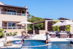 a group of children playing in a swimming pool at Ilhabela Beach Residences in Ilhabela