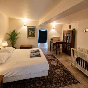 a bedroom with a bed and a table and a crib at Le Jeu de Paume - Bail Partner in Mailly-le-Château