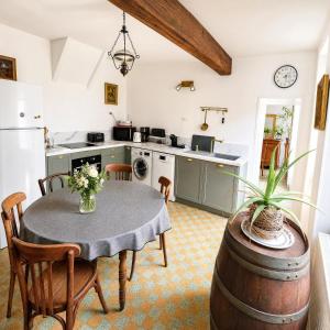 a kitchen with a table and chairs and a kitchen with a refrigerator at Le Jeu de Paume - Bail Partner in Mailly-le-Château +17 photos