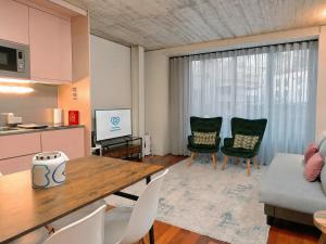 a kitchen and a living room with a table and chairs at Fervença Apartments in Vila Nova de Gaia +57 photos