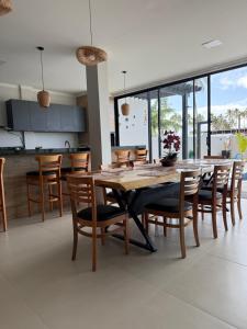 a kitchen and dining room with a wooden table and chairs at Casa 03 suites Maragogi Japaratinga in Japaratinga