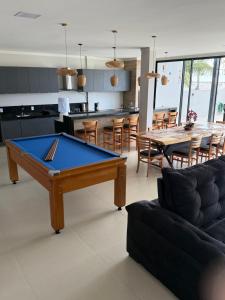 a living room with a pool table and a kitchen at Casa 03 suites Maragogi Japaratinga in Japaratinga
