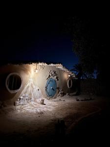 a building with a blue door at night at Hobbit-Hole in Siwa in Siwa