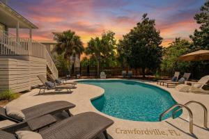 a swimming pool with chairs and an umbrella at Blue Mountain View - Private Pool in Santa Rosa Beach