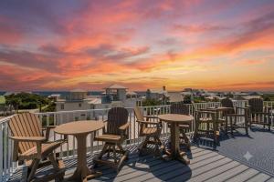 a row of tables and chairs on a deck with a sunset at Blue Mountain View - Private Pool in Santa Rosa Beach +44 photos