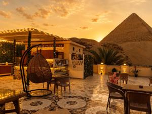 a woman sitting on a patio in front of the pyramids at Crystal pyramid inn in Cairo