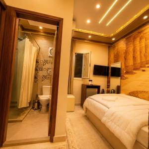 a bedroom with a large bed and a bathroom at Crystal pyramid inn in Cairo +150 photos
