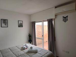 a bedroom with a bed and a large window at Punto Centro in Venado Tuerto