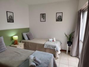 a small room with two beds and a window at Punto Centro in Venado Tuerto