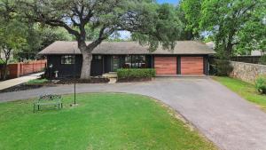a house with a bench in front of a driveway at Boerne Birdie Ranch in Boerne