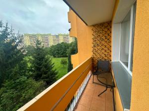 a balcony with a chair and a view of a building at Apartament Palisadowa 78 in Wałbrzych