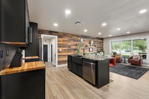 a kitchen with black appliances and a living room at Boerne Birdie Ranch in Boerne