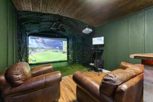 a living room with two leather chairs and a large screen television at Boerne Birdie Ranch in Boerne